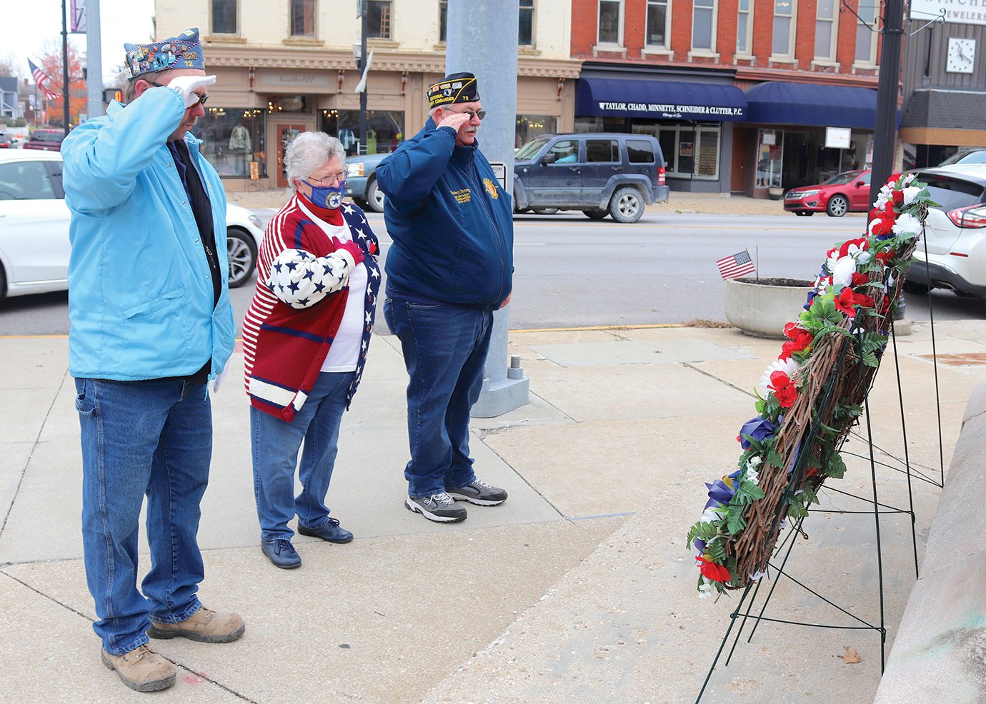 Keith Switzer, from left, Rosemary Hutchison and Rodney Strong salute fallen military personnel Wednesday at the base of the city's Soldier's and Sailor's Monument downtown.